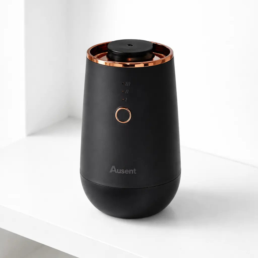 Black and rose gold diffuser on a white surface with a white background