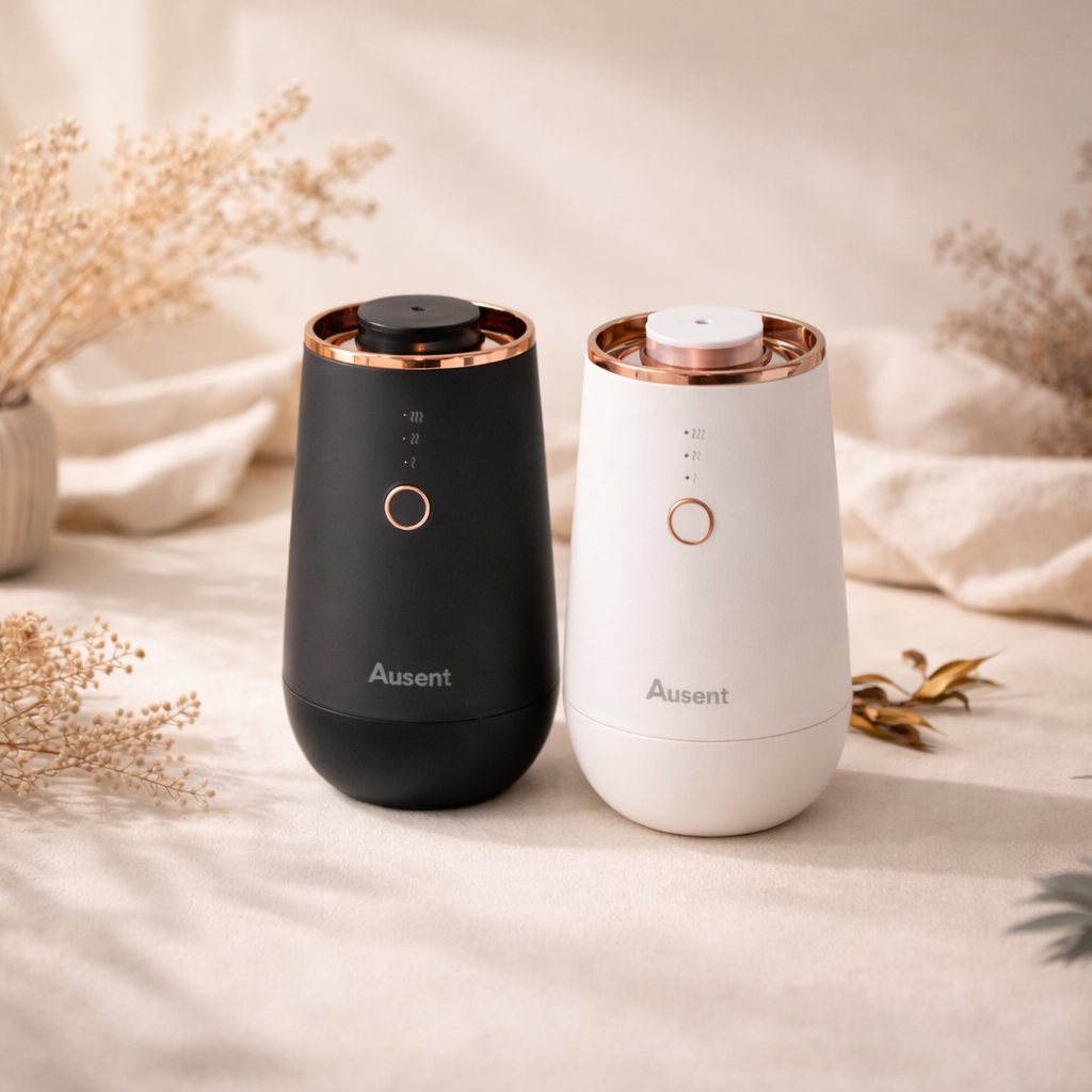 Two black and white diffusers with rose gold accents on a neutral background.