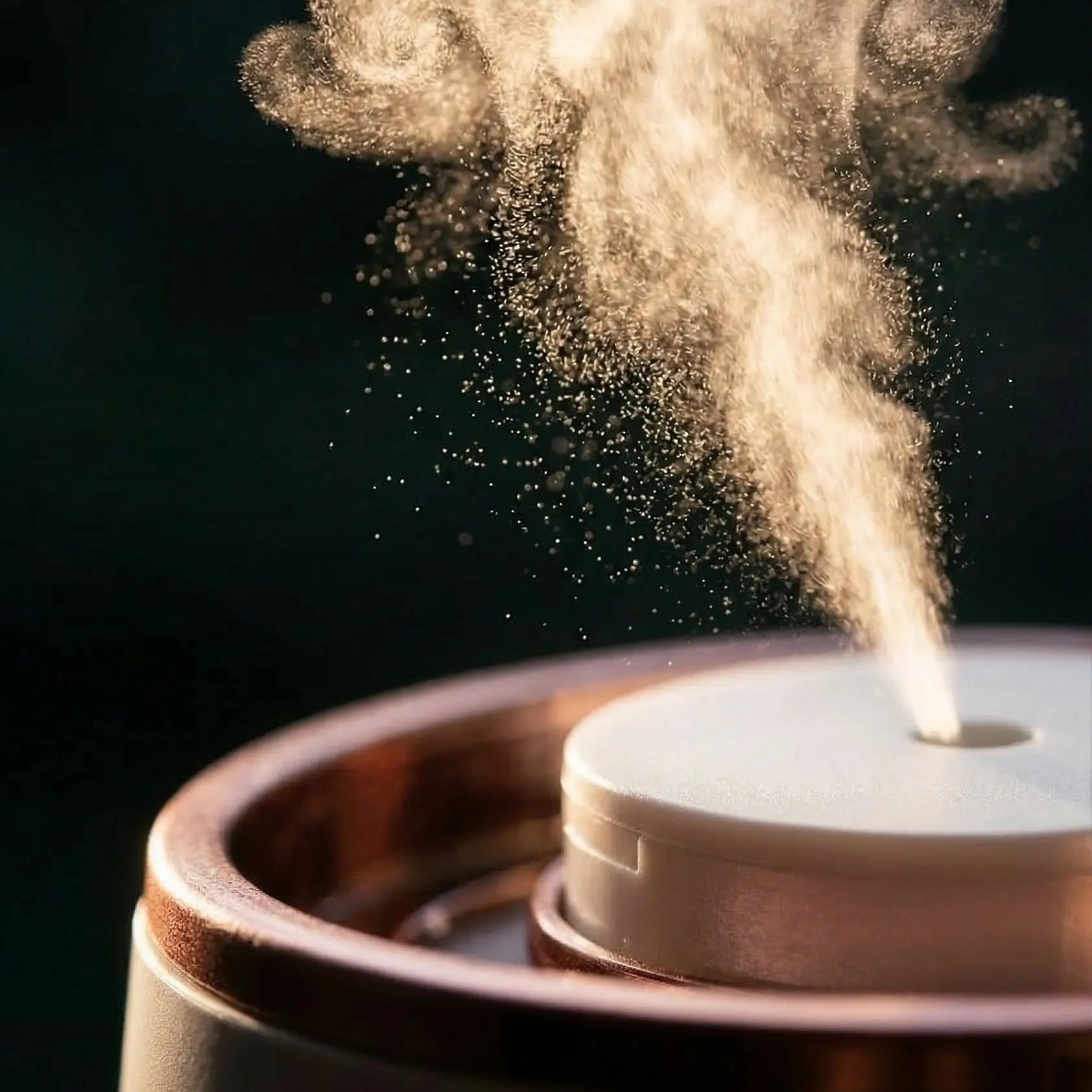 Diffuser emitting mist against a dark background